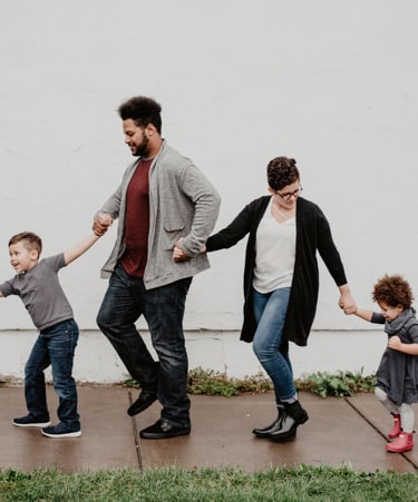 A photo of a young family holding hands